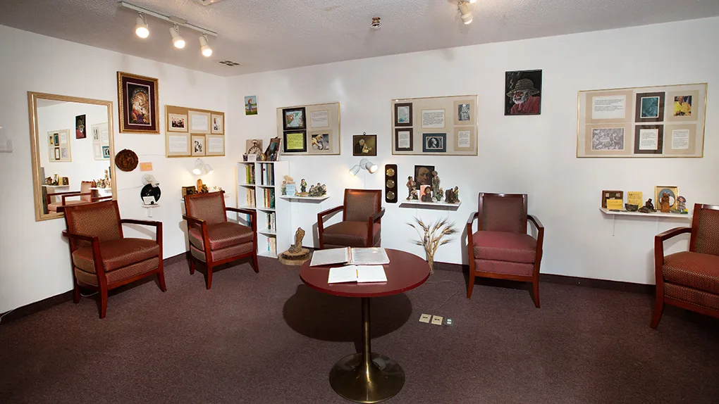 A quiet sitting room with armchairs, keepsakes and framed memories