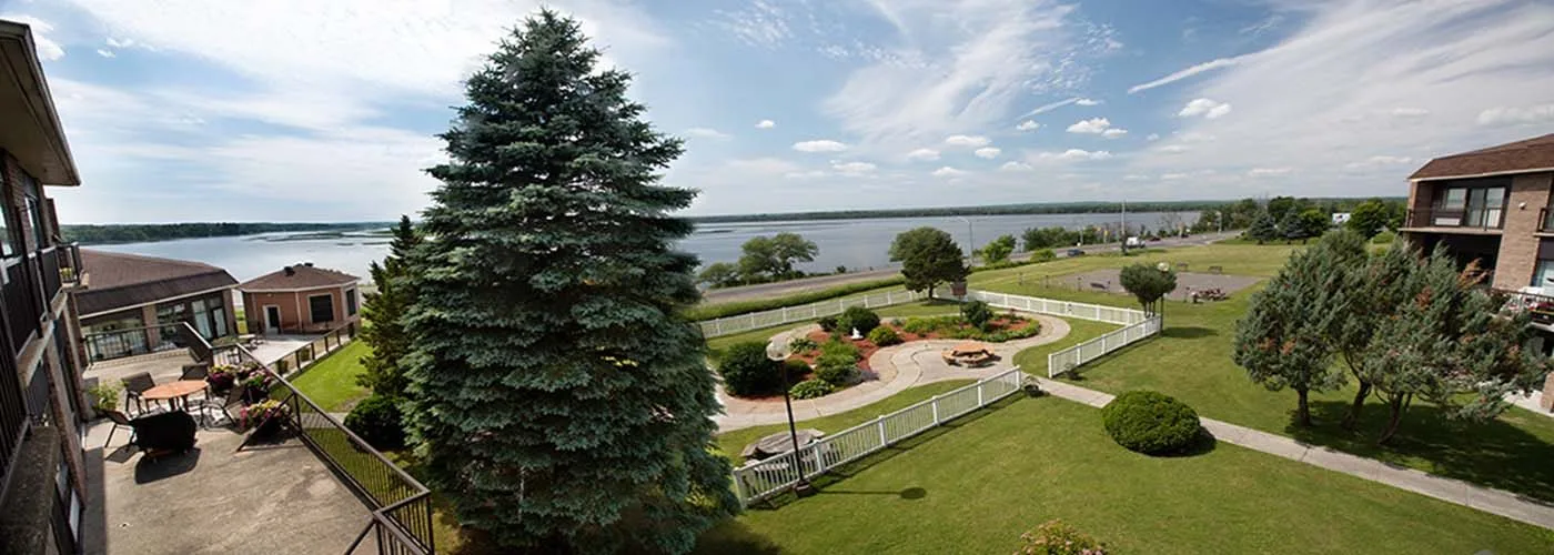 View from a balcony at Jardins Belle Rive over the terraced gardens, walking paths and the wide Ottawa River